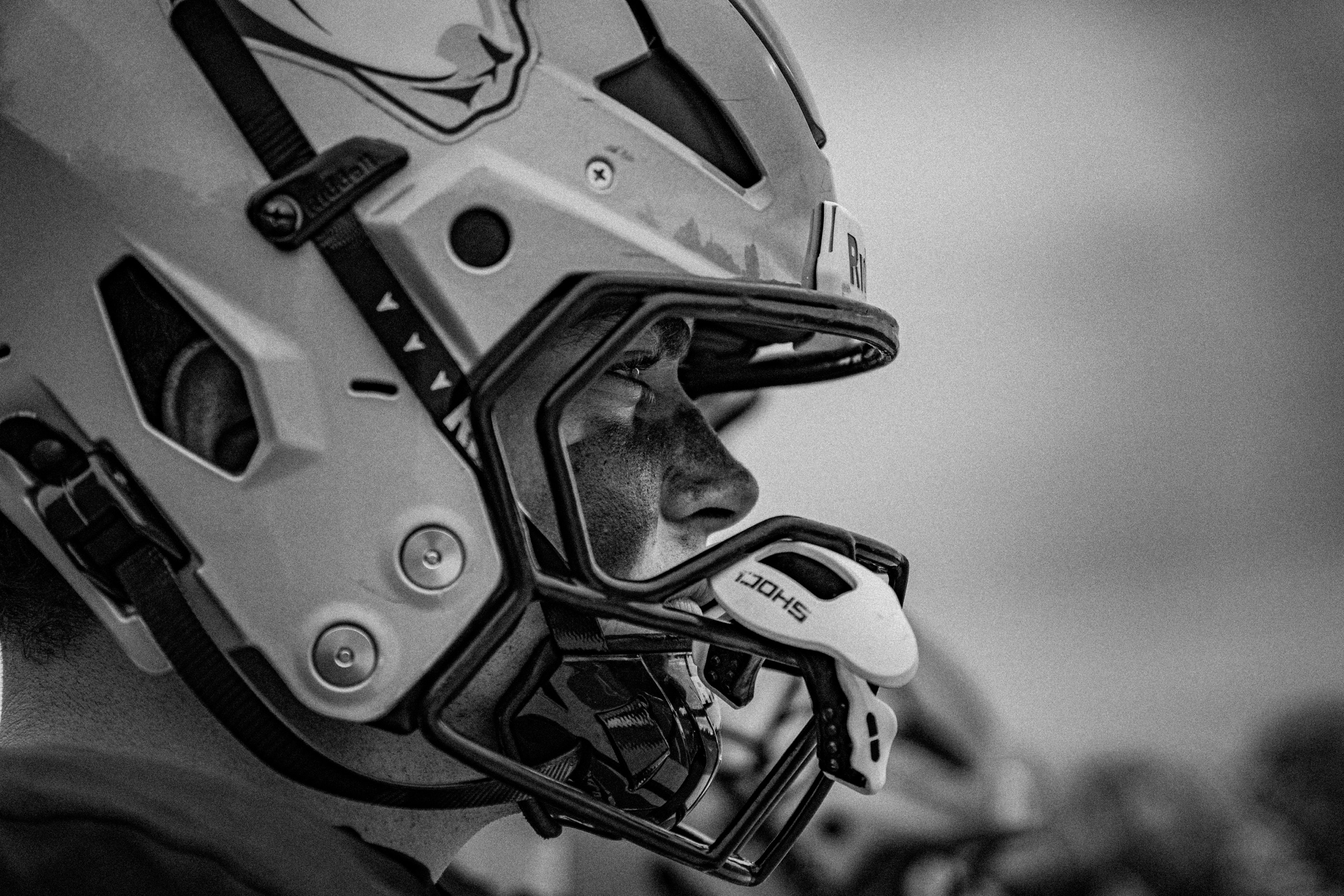 Black and white close-up profile of a football player in a helmet